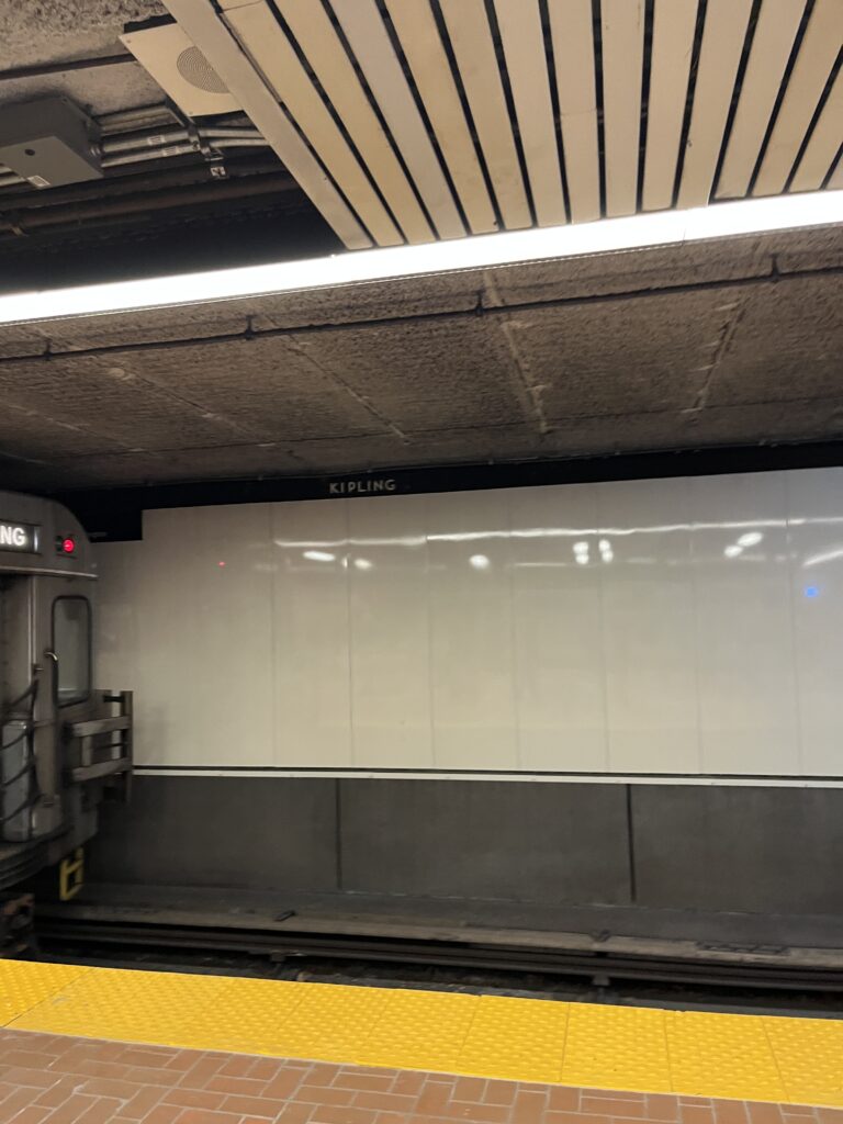 the wall at Kipling Station, with a subway car on the left