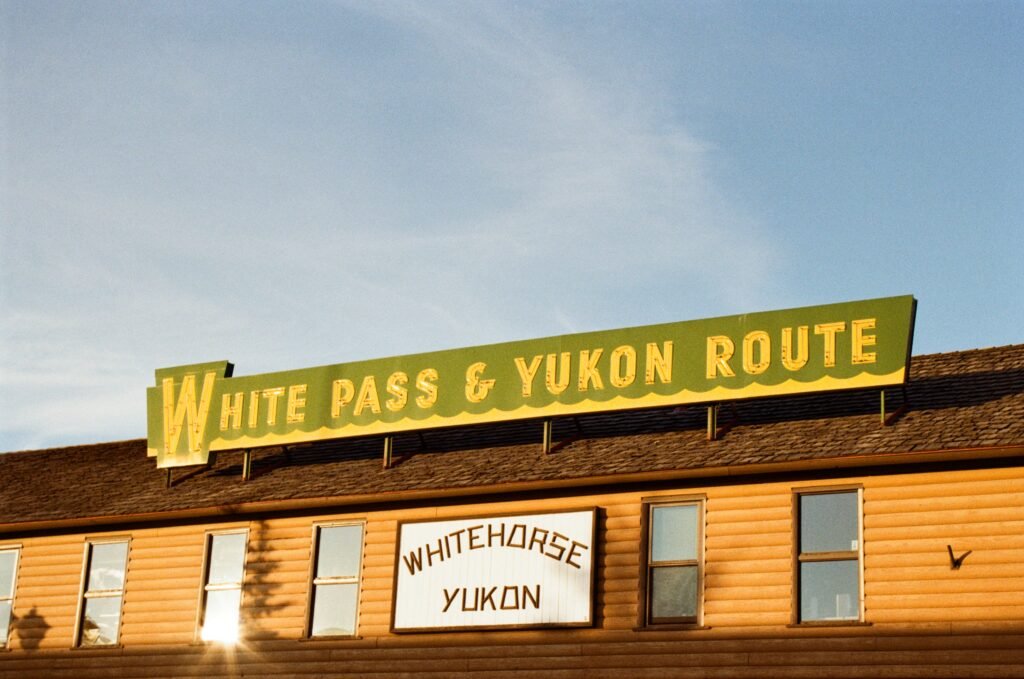 a sign saying WHITE PASS & YUKON ROUTE with another below saying WHITEHORSE YUKON