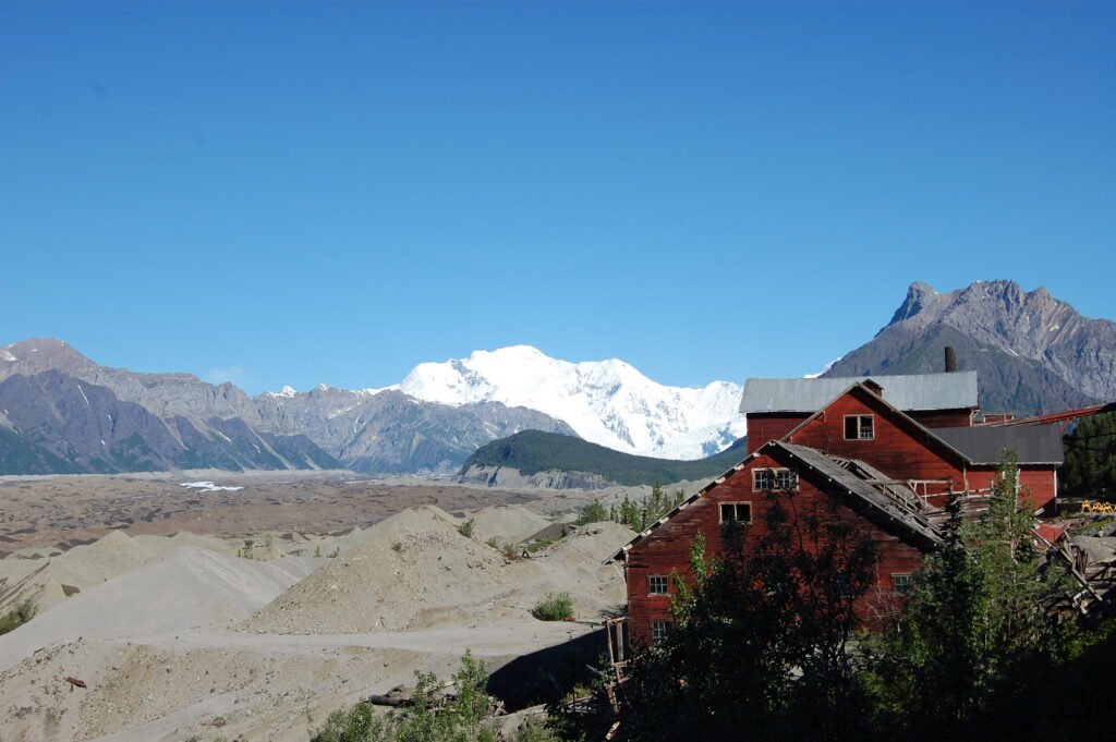 Mountains with red, historical mine buildings in the foreground
