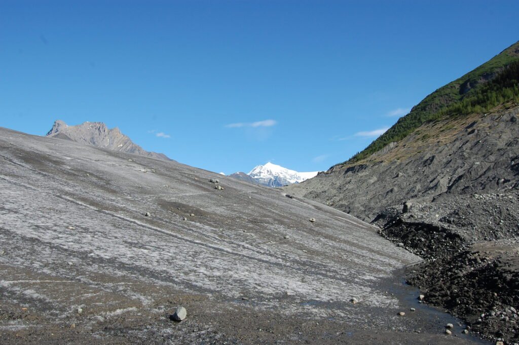 a gently sloping glacier with mountains in the background