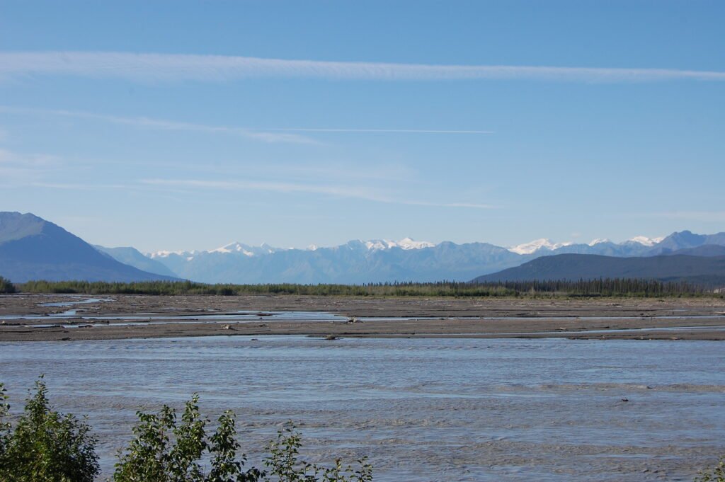 a broad braided river with mountains in the background