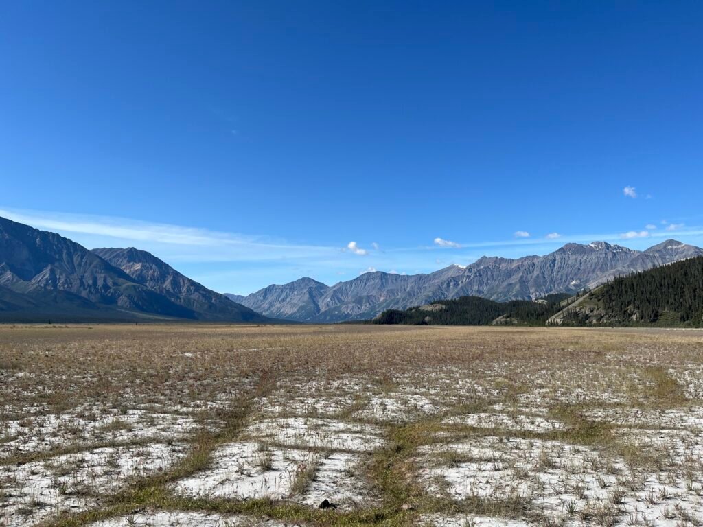 a dry plain foreground with tall mountains in the background