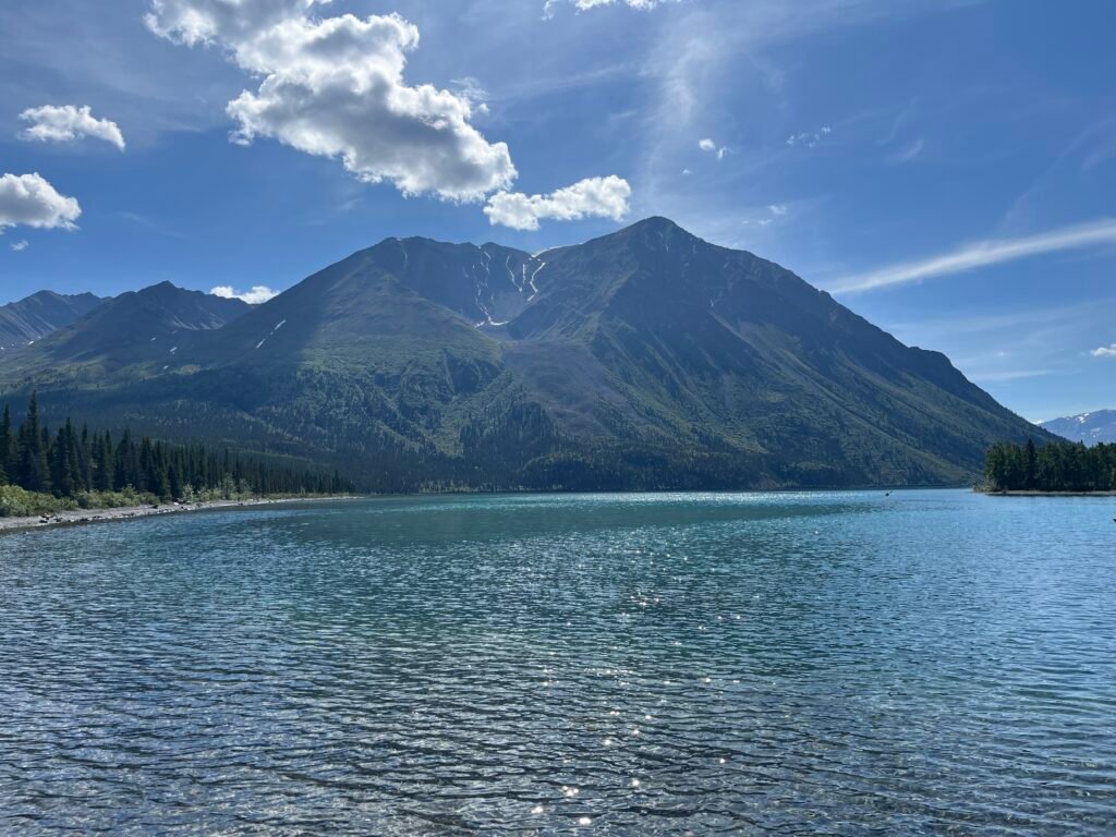 a light blue lake with a mountain in the background, which has a bowl looking like a throne